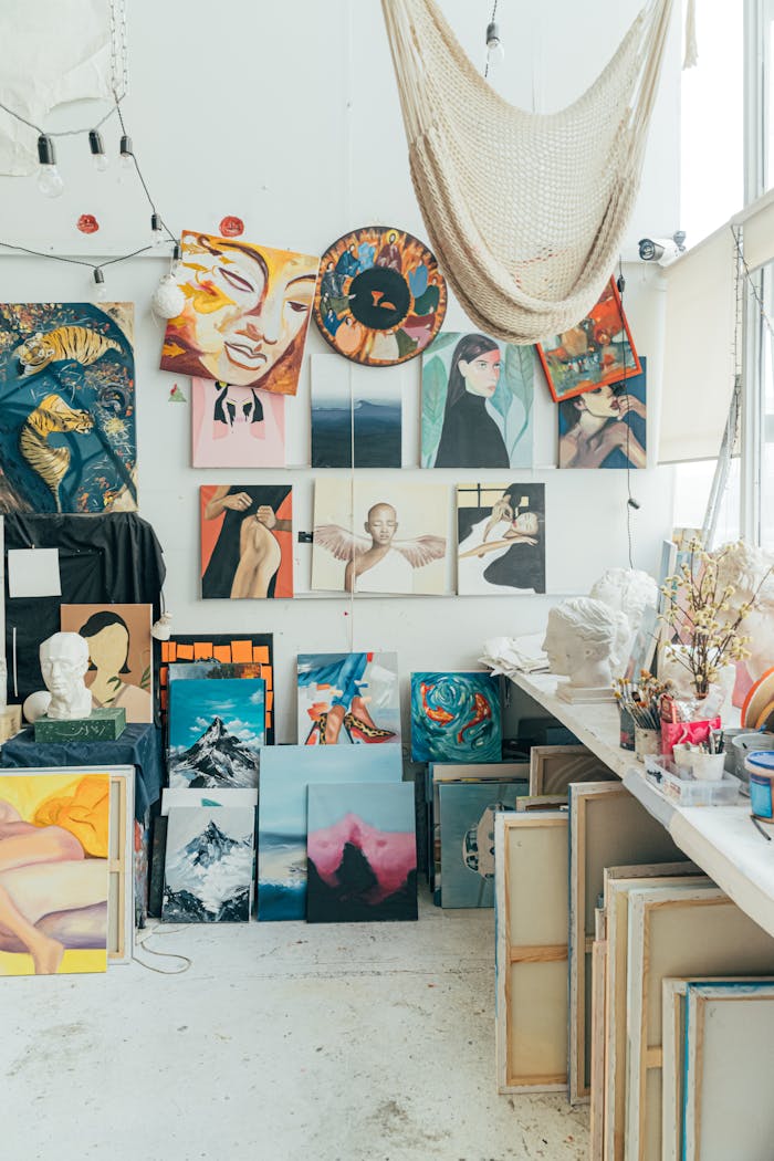 A vibrant art studio filled with colorful paintings and canvases on display.